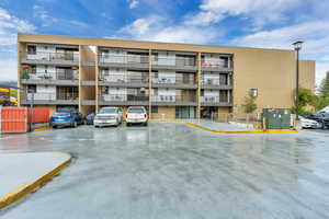 View of apartment building / complex featuring uncovered parking
