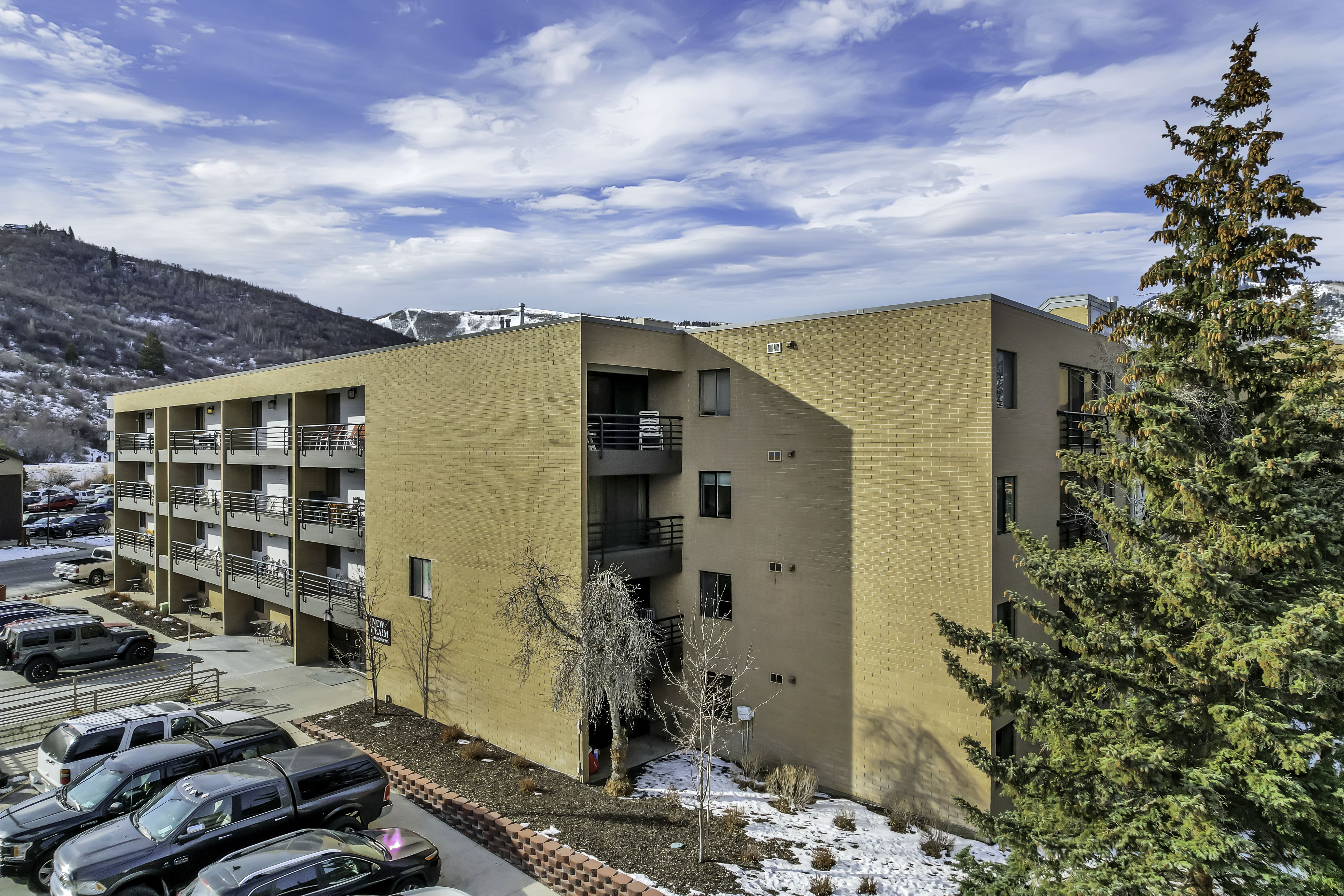 Snow covered building featuring a view of apartment building / complex and a mountain view