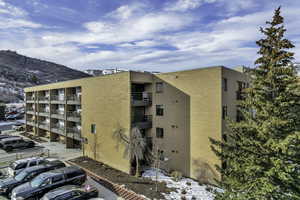 Snow covered building featuring a view of apartment building / complex and a mountain view