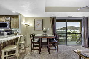 Dining space with light carpet and a textured ceiling