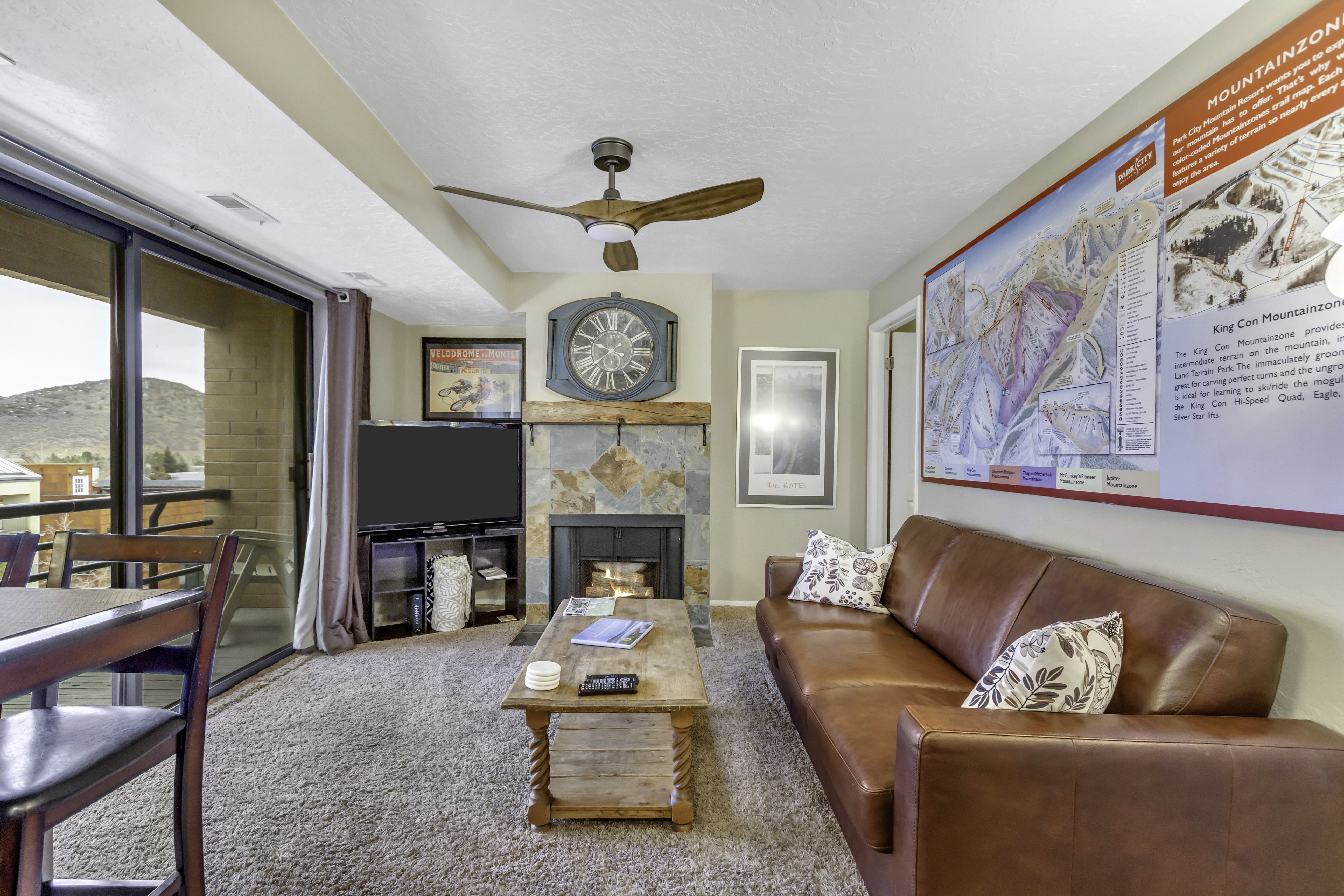 Living room with a tile fireplace, a mountain view, carpet floors, and ceiling fan