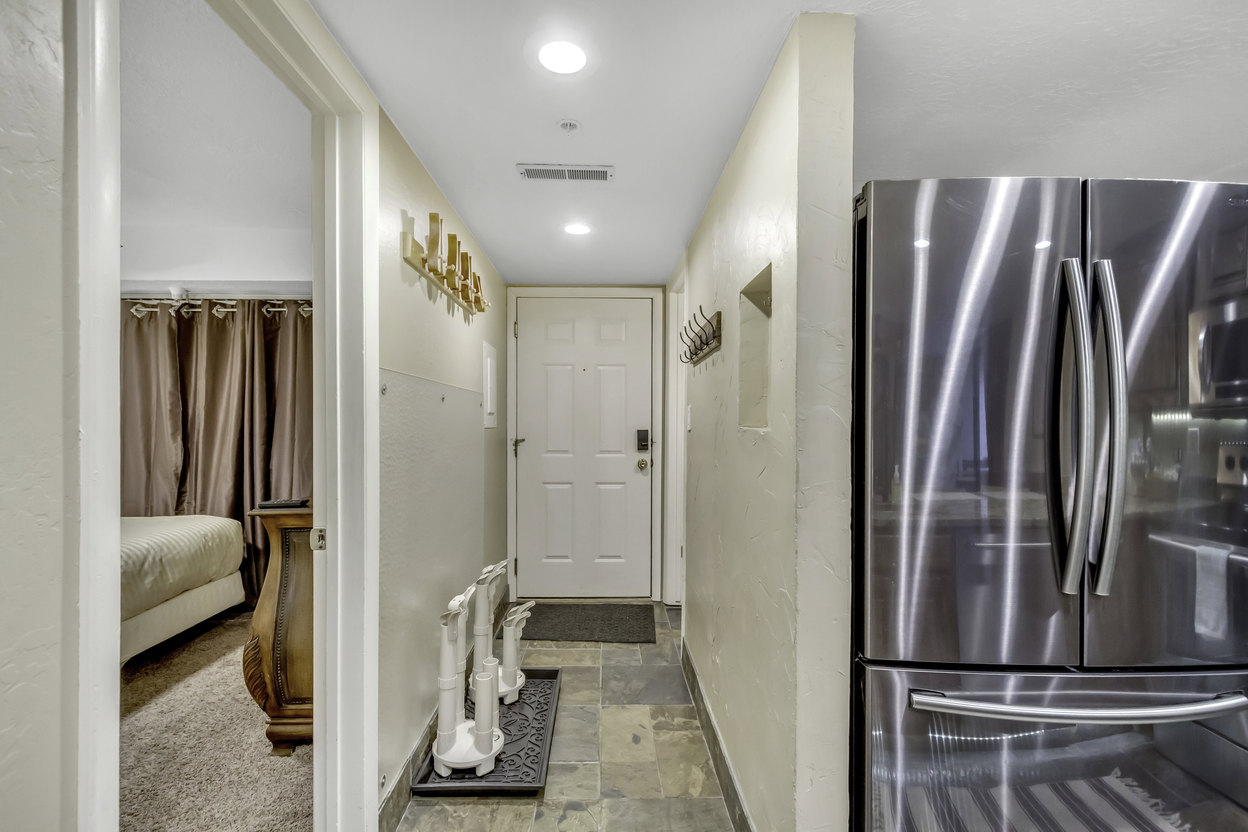 Hallway featuring light stone finish floors and recessed lighting
