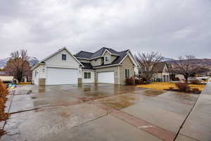 View of front of home featuring board and batten siding, stone siding, driveway, and a shingled roof