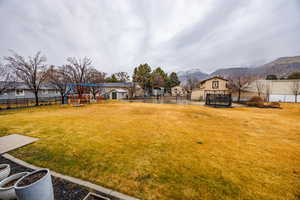 Fenced backyard featuring a playground and a mountain view