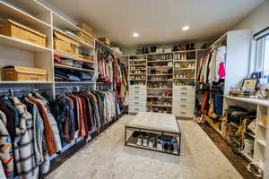 Walk in closet with light wood finished floors