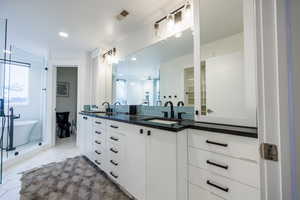 Bathroom with double vanity, light tile patterned flooring, a freestanding tub, and recessed lighting