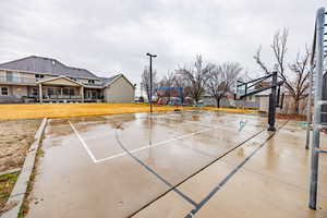 View of basketball court with community basketball court and a lawn