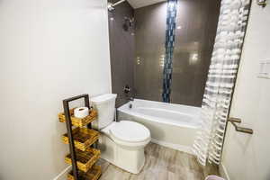Full bathroom featuring shower / tub combo with curtain and wood finished floors