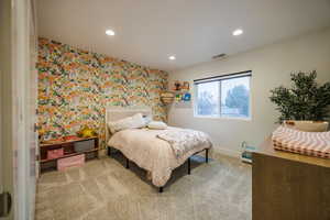 Bedroom featuring wallpapered walls, recessed lighting, light colored carpet, and an accent wall