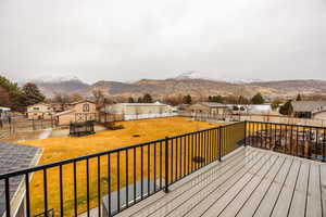Deck with a mountain view, a residential view, and a fenced backyard