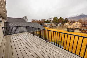 Wooden deck with a trampoline, an outdoor structure, and a residential view