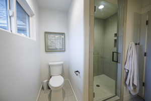 Bathroom with a stall shower and tile patterned floors