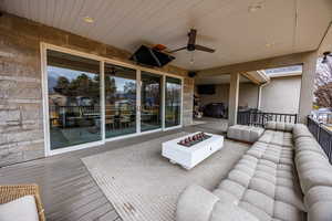 Wooden terrace featuring ceiling fan and an outdoor fire pit