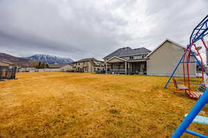 View of yard featuring a playground, a patio area, a mountain view, and a residential view