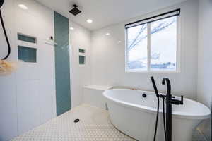 Bathroom featuring tiled shower, recessed lighting, tile walls, and a freestanding tub
