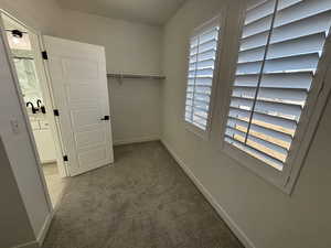Walk in closet with carpet flooring and a sink