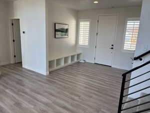 Entryway with light wood finished floors and recessed lighting