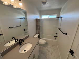 Full bathroom with shower / tub combo with curtain, vanity, and light marble finish floors