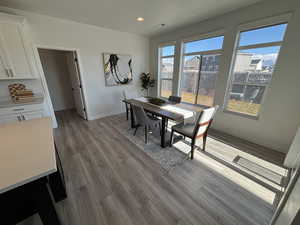Dining room with light wood-style floors and recessed lighting