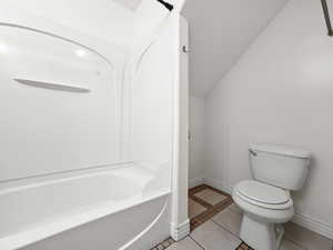 Full bath with light tile patterned flooring, and bathing tub / shower combination