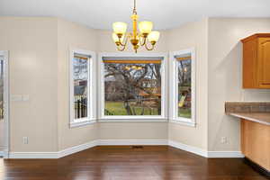 Dining area with a chandelier and dark wood finished floors