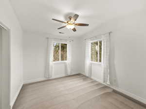 Bedroom with ceiling fan, light carpet, and natural light