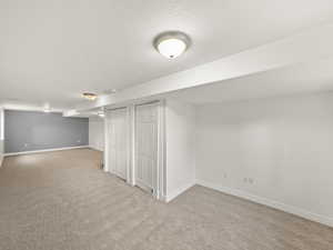 Finished basement featuring baseboards and light colored carpet