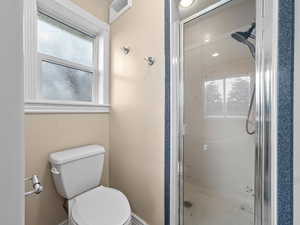 Bathroom featuring a shower stall and toilet