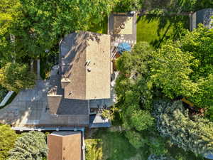 Aerial view of property and surrounding area with a tree filled landscape