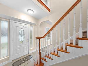 Entrance foyer featuring stairway and light tile patterned floors