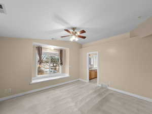 Spare room featuring ceiling fan, light carpet, and vaulted ceiling