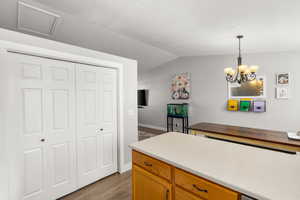 Kitchen with wood counters, suspended lighting, dark wood-type flooring, vaulted ceiling, and wood finish cabinets
