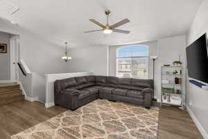 Living room featuring wood finished floors, a chandelier, and a ceiling fan