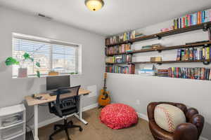 Office space with light colored carpet and baseboards