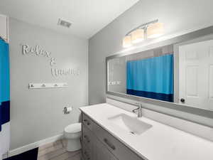 Full bathroom featuring a shower with shower curtain, vanity, and light wood finished floors
