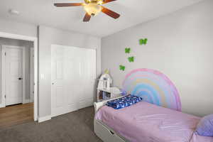 Bedroom with carpet floors, ceiling fan, and a closet