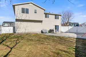 Rear view of property with a fenced backyard, a patio, and a gate