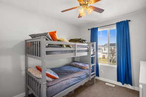 Bedroom featuring dark colored carpet and a ceiling fan