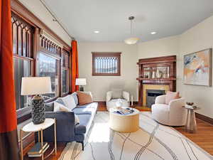 Living area featuring a fireplace with flush hearth, wood finished floors, and recessed lighting