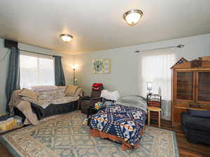 Bedroom featuring dark wood-style flooring and a textured ceiling