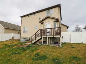 Rear view of house featuring a gate, a wooden deck, a fenced backyard, and a patio