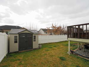Fenced backyard featuring a shed