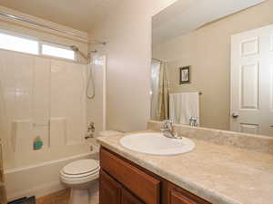 Bathroom with shower / tub combo, vanity, and light tile patterned floors