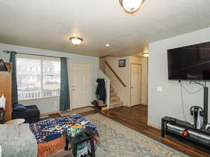 Living room featuring a textured ceiling and dark wood finished floors