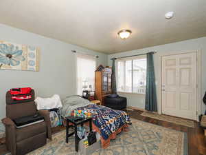 Bedroom with dark wood finished floors and a textured ceiling