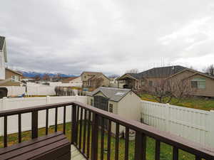 Deck featuring a residential view, a shed, a fenced backyard, and a mountain view
