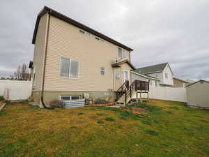 Rear view of property featuring a fenced backyard and a storage unit