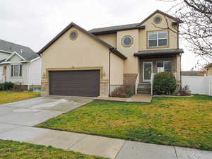 Traditional home featuring concrete driveway, brick siding, stucco siding, and a garage
