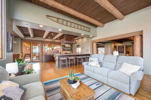 Living room with a wood ceiling with exposed beams, light wood-type flooring, healthy amount of natural light, and recessed lighting