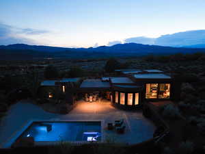 Rear view of house with a mountain view, an outdoor pool, and a patio